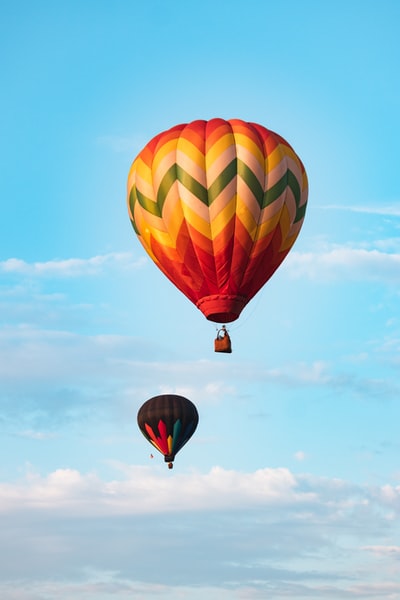 During the day, under the blue sky, green, yellow and red balloon flight in mid air
